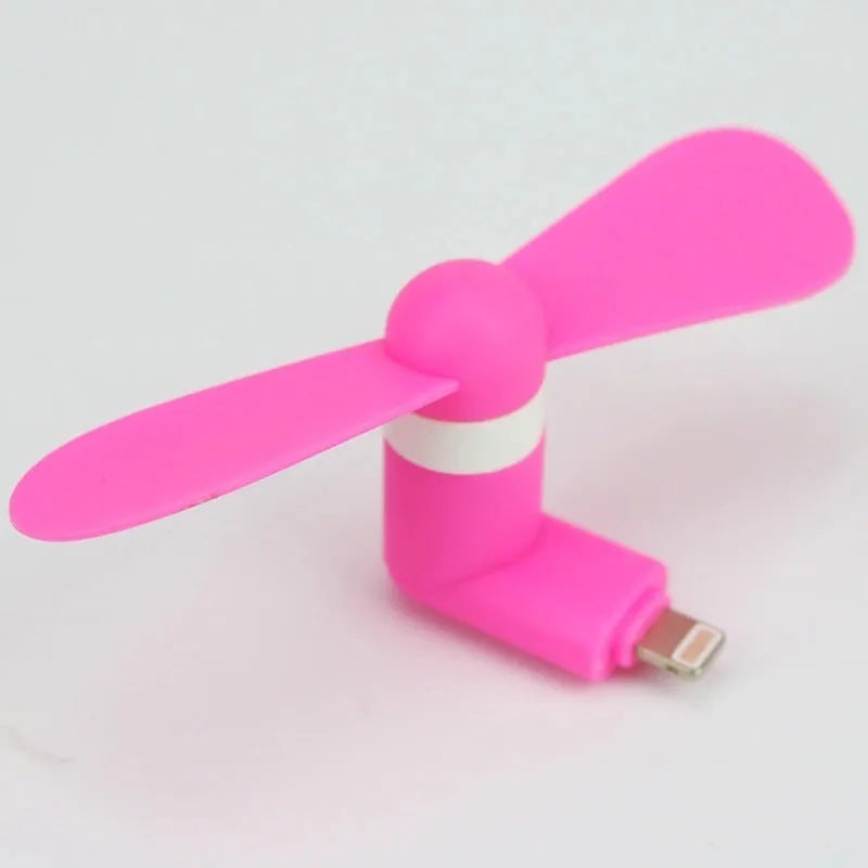 White portable mobile phone mini fan with plastic blades attached to smartphone