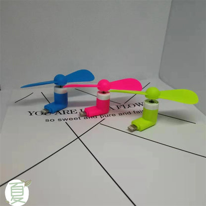 White portable mobile phone mini fan with plastic blades attached to smartphone