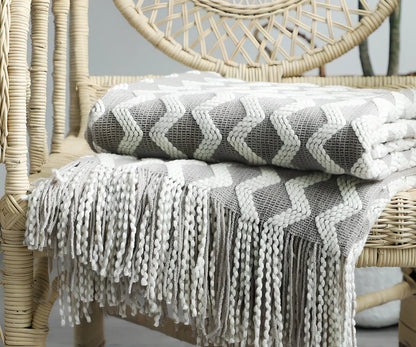 Nordic knitted decorative blanket with striped pattern and tassels in light grey colour