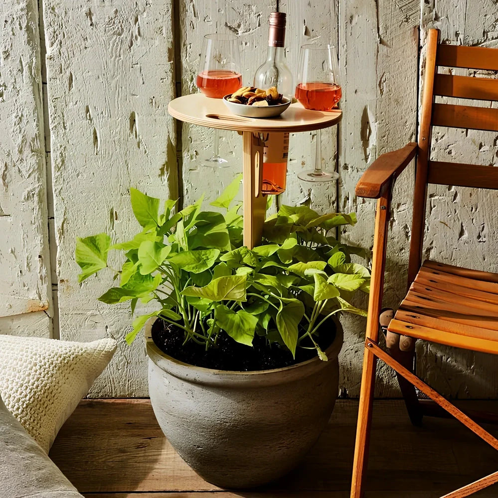 Wooden folding wine table with ground stakes holding wine bottle and glasses outdoors