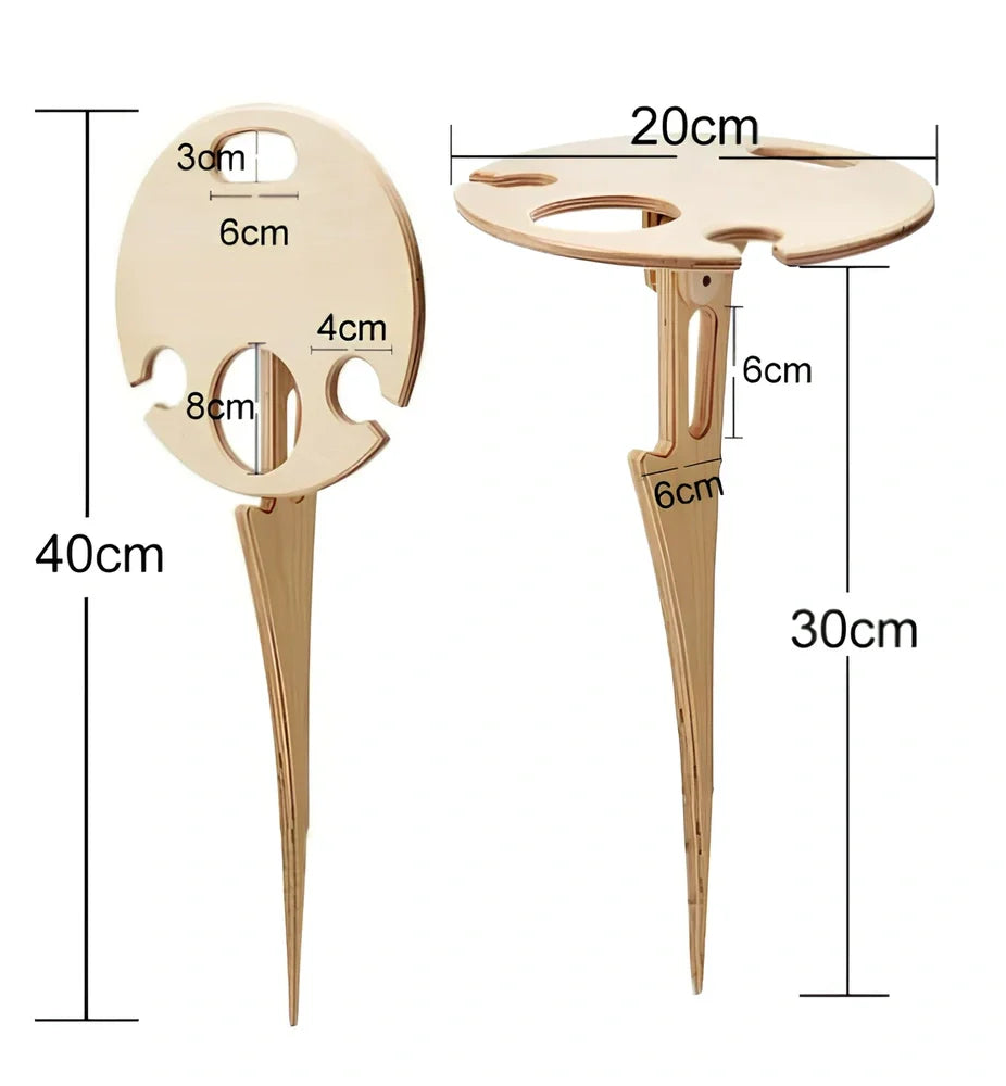 Wooden folding wine table with ground stakes holding wine bottle and glasses outdoors