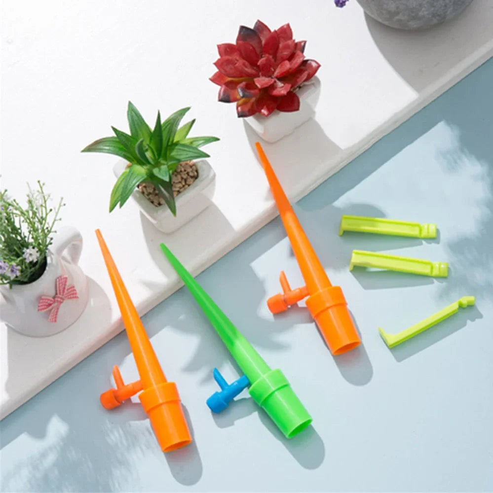 Set of green and orange plastic watering spikes, 16.5 cm tall, for garden plant hydration