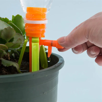 Set of green and orange plastic watering spikes, 16.5 cm tall, for garden plant hydration