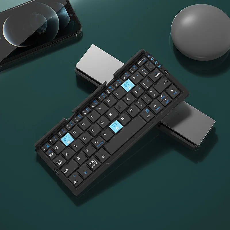 Silver white folding Bluetooth keyboard with stand holding tablet, showing compact folded size