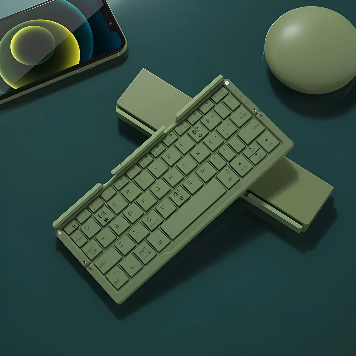 Silver white folding Bluetooth keyboard with stand holding tablet, showing compact folded size