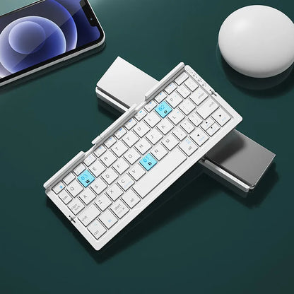 Silver white folding Bluetooth keyboard with stand holding tablet, showing compact folded size