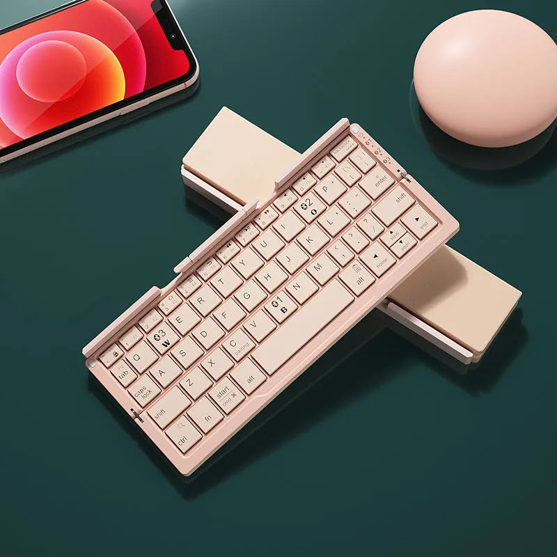 Silver white folding Bluetooth keyboard with stand holding tablet, showing compact folded size