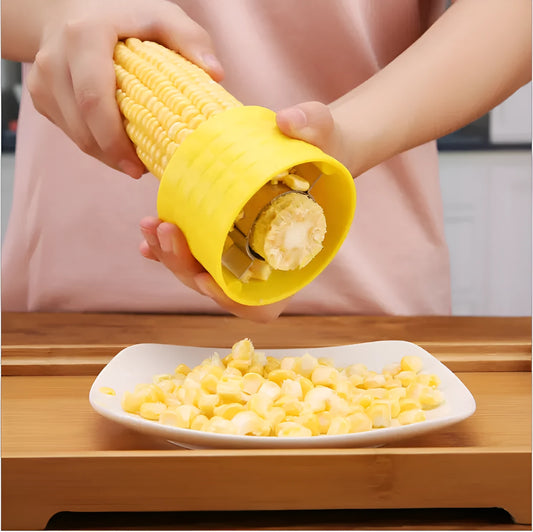 Yellow manual corn grinder thresher with corn-shaped design and stainless steel gear for peeling corn kernels.