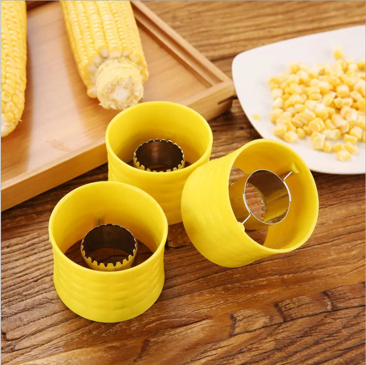 Yellow manual corn grinder thresher with corn-shaped design and stainless steel gear for peeling corn kernels.