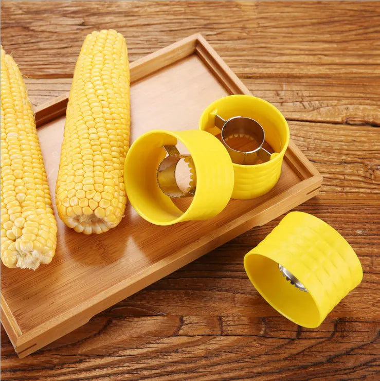 Yellow manual corn grinder thresher with corn-shaped design and stainless steel gear for peeling corn kernels.