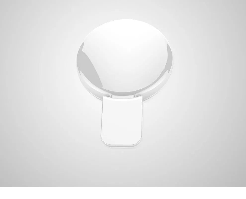 Round black mobile phone fill light with adjustable clip attached to a smartphone.