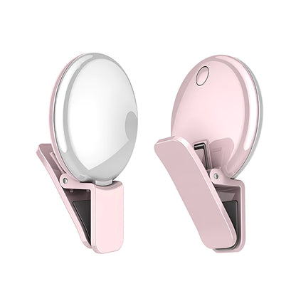 Round black mobile phone fill light with adjustable clip attached to a smartphone.