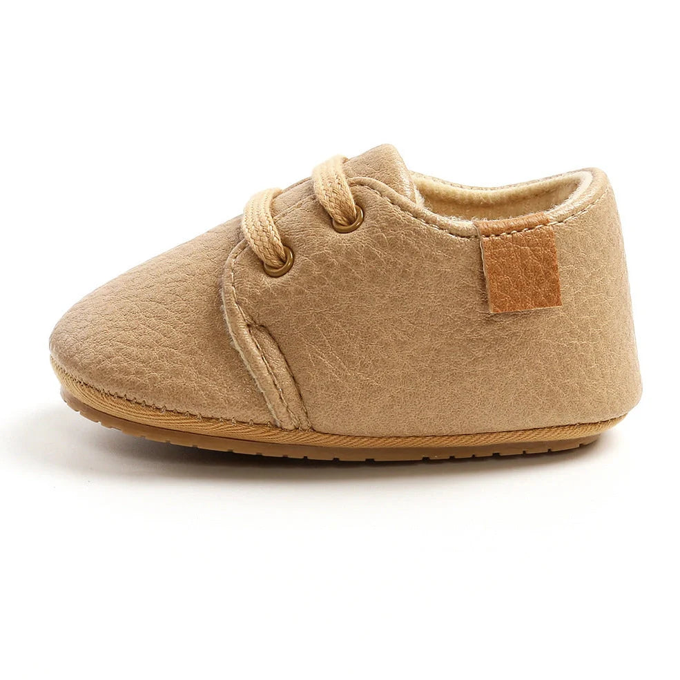Soft leather baby moccasins with anti-slip rubber soles in beige colour showing low height design