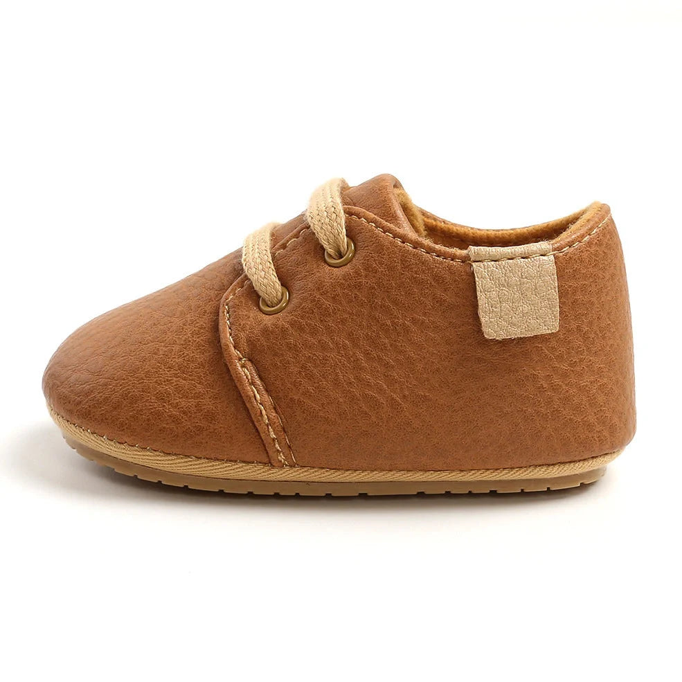 Soft leather baby moccasins with anti-slip rubber soles in beige colour showing low height design