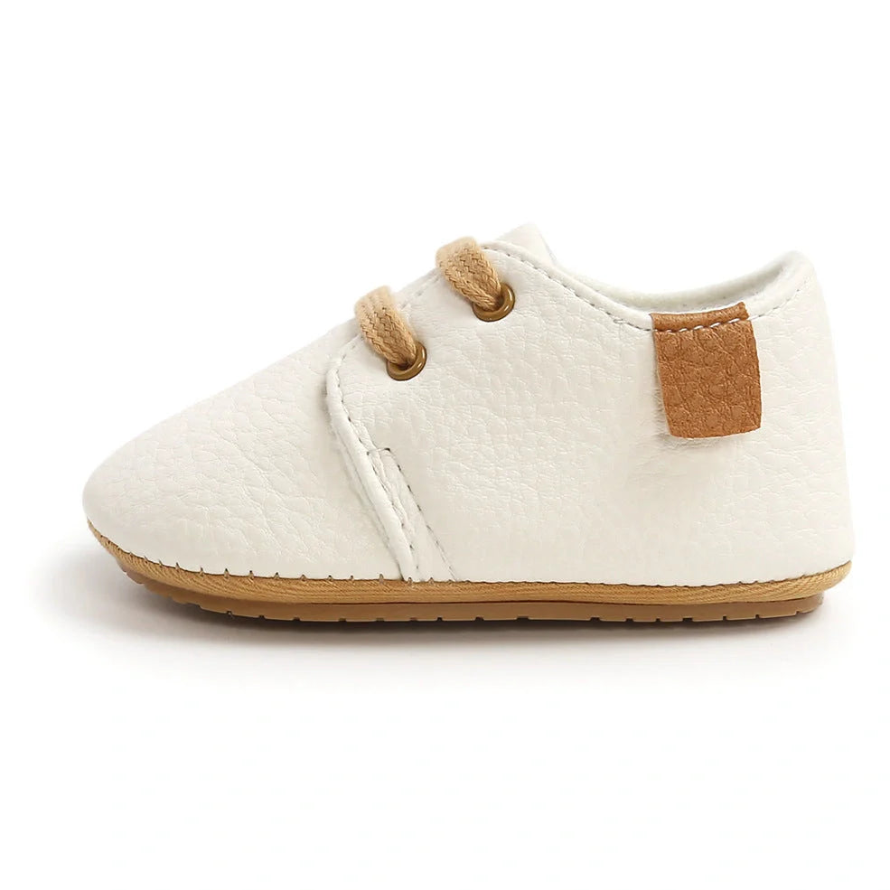Soft leather baby moccasins with anti-slip rubber soles in beige colour showing low height design