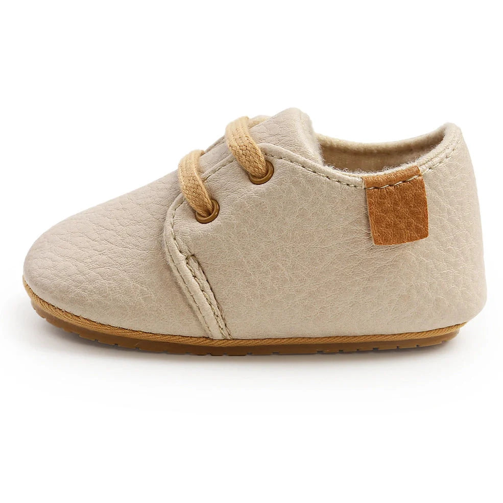Soft leather baby moccasins with anti-slip rubber soles in beige colour showing low height design