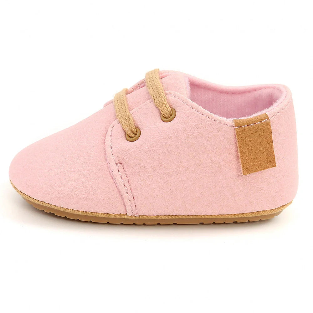 Soft leather baby moccasins with anti-slip rubber soles in beige colour showing low height design