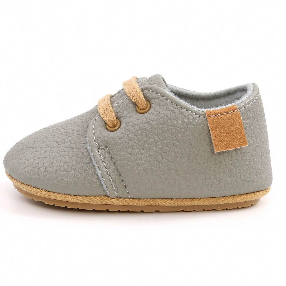 Soft leather baby moccasins with anti-slip rubber soles in beige colour showing low height design