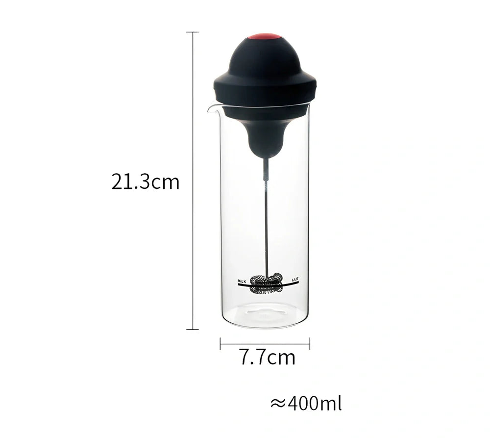 Black electric milk frother with lead-free glass jar and stainless steel whisk on kitchen counter