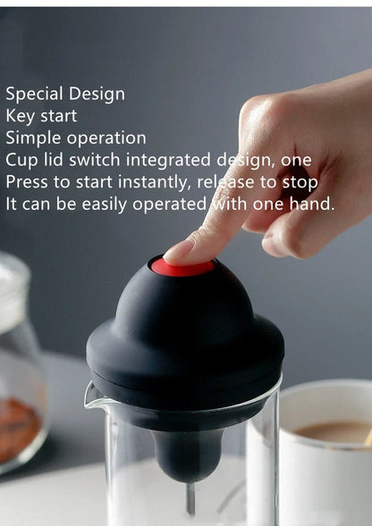 Black electric milk frother with lead-free glass jar and stainless steel whisk on kitchen counter