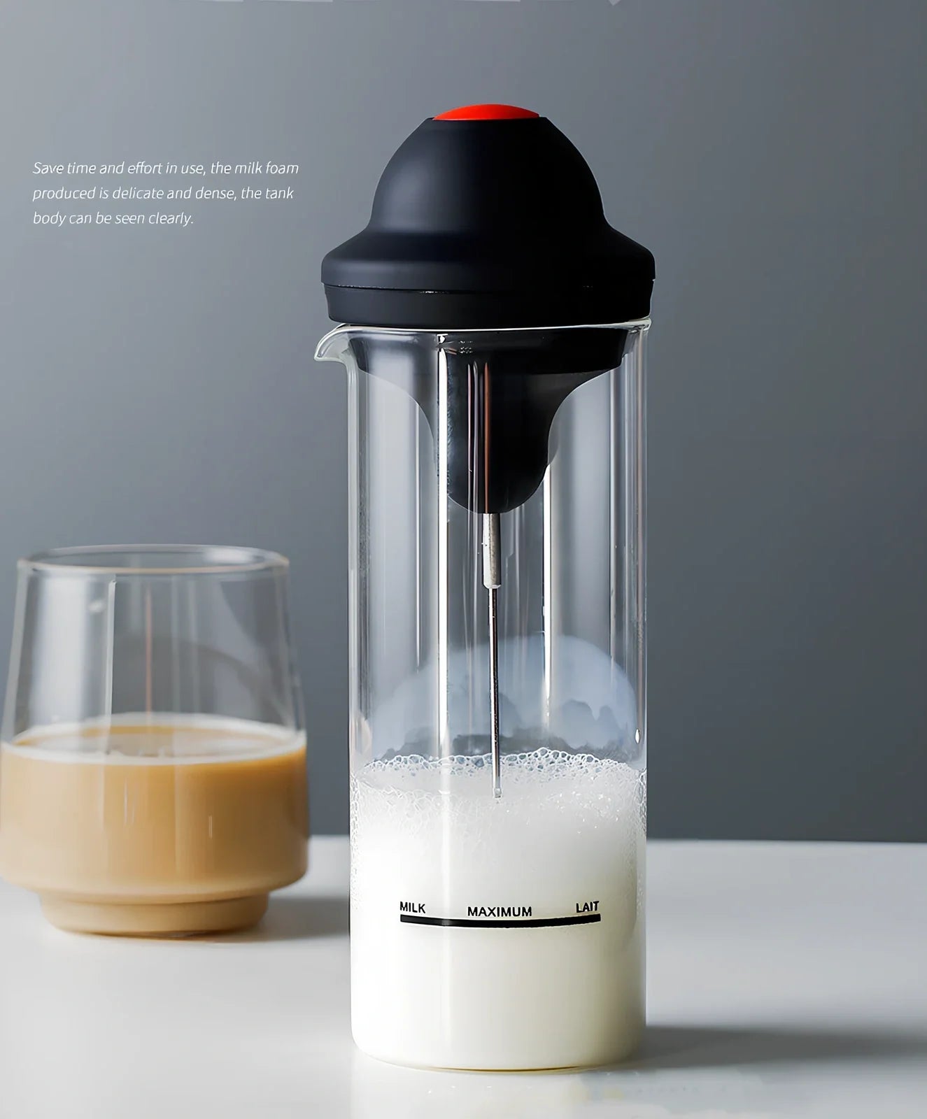 Black electric milk frother with lead-free glass jar and stainless steel whisk on kitchen counter