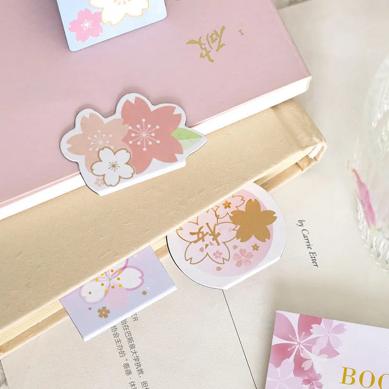 Set of four sakura-themed magnetic bookmarks showing cherry blossom designs on stone paper