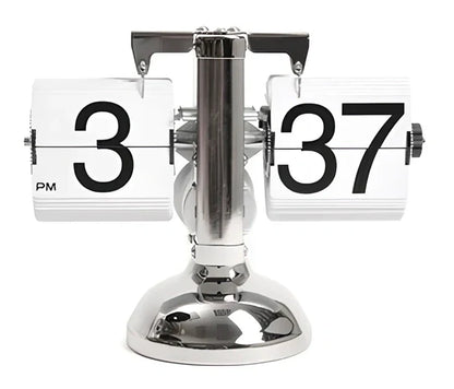 Black and white flip digital clock showing 12:34 with retro flip digits on wooden table