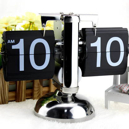 Black and white flip digital clock showing 12:34 with retro flip digits on wooden table
