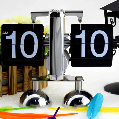 Black and white flip digital clock showing 12:34 with retro flip digits on wooden table