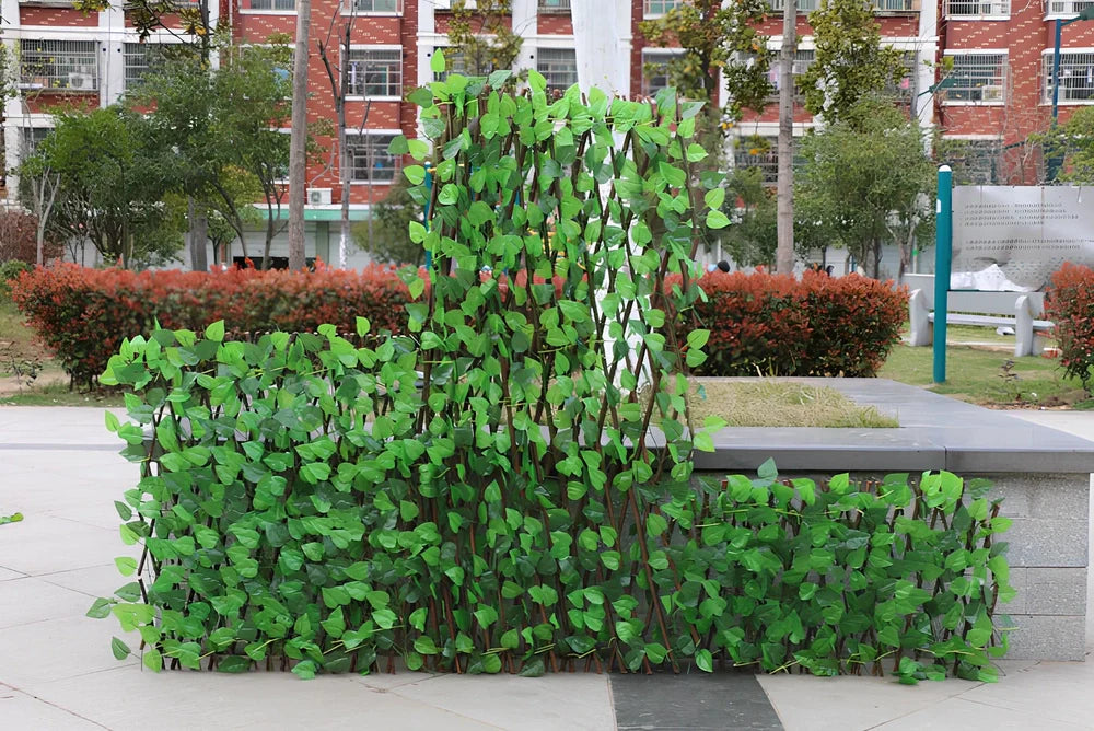 Simulation wooden garden fence with telescopic sections expanded to 60cm width beside flowering plants