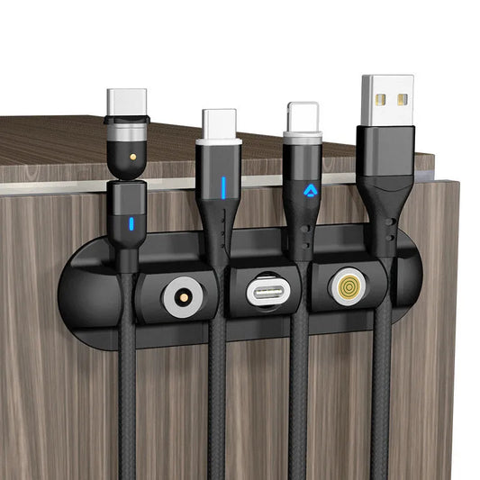 Black soft plastic magnetic data cable organizer on a desktop, holding charging cables neatly in place