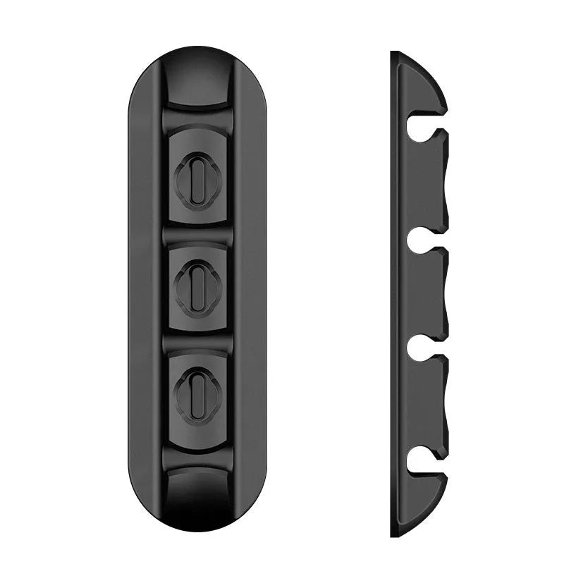 Black soft plastic magnetic data cable organizer on a desktop, holding charging cables neatly in place