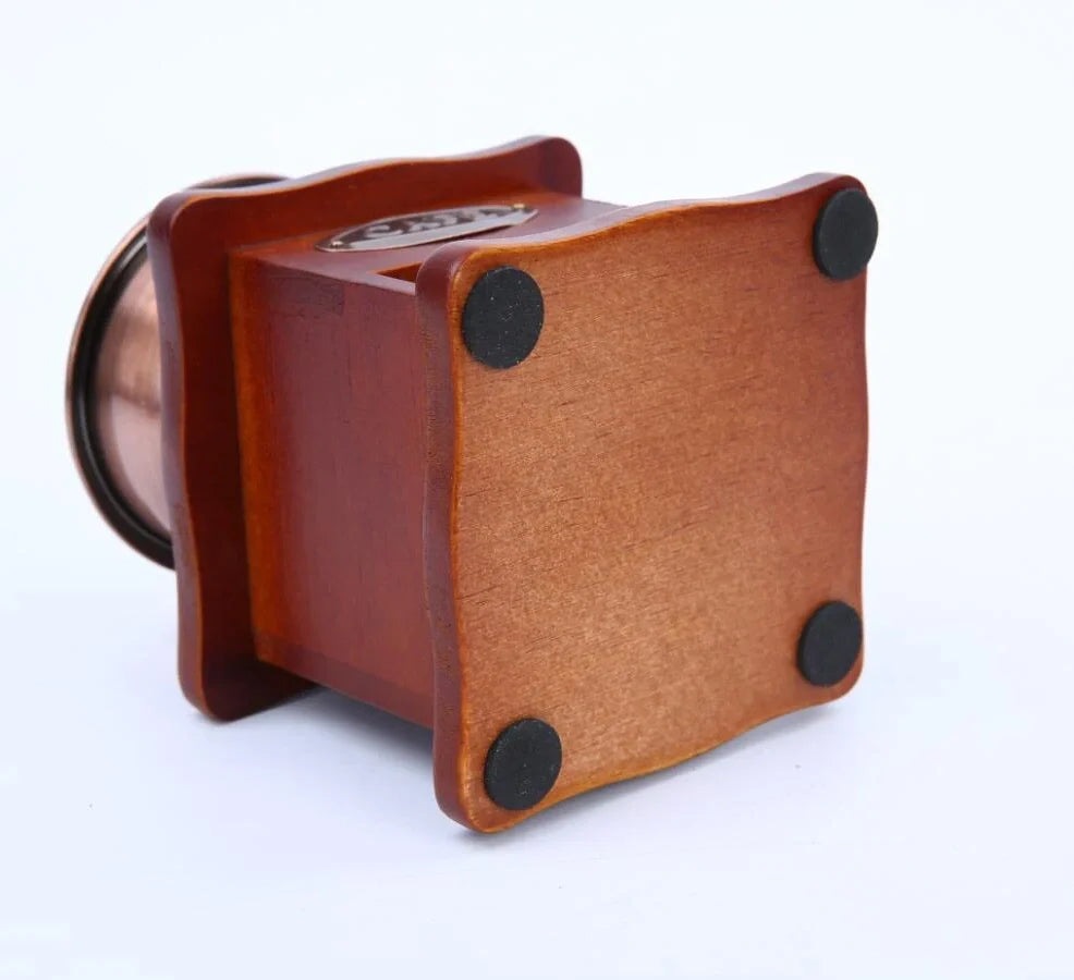 Red manual coffee grinder with pine wood housing and ceramic burrs measuring 10x10x17cm