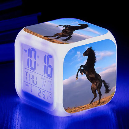 Square creative alarm clock showing LED time display, thermometer reading, and colour-changing design on bedside table
