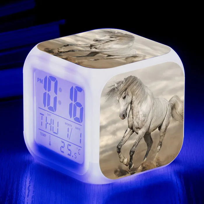 Square creative alarm clock showing LED time display, thermometer reading, and colour-changing design on bedside table