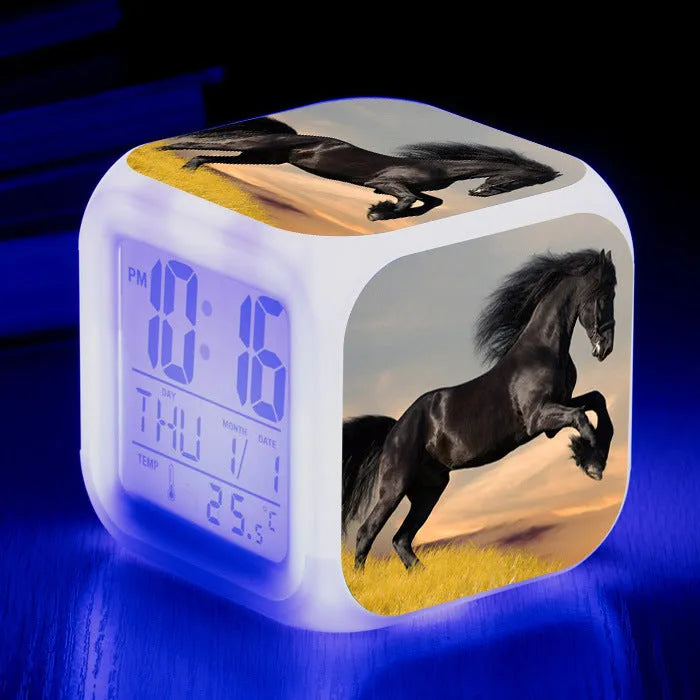 Square creative alarm clock showing LED time display, thermometer reading, and colour-changing design on bedside table