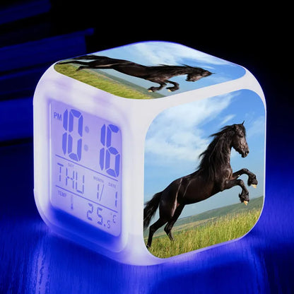 Square creative alarm clock showing LED time display, thermometer reading, and colour-changing design on bedside table