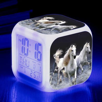 Square creative alarm clock showing LED time display, thermometer reading, and colour-changing design on bedside table