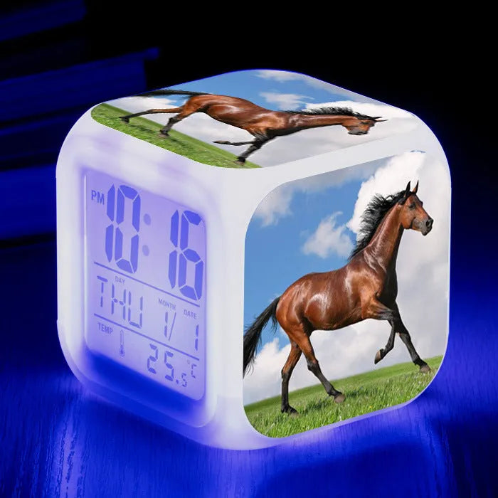 Square creative alarm clock showing LED time display, thermometer reading, and colour-changing design on bedside table