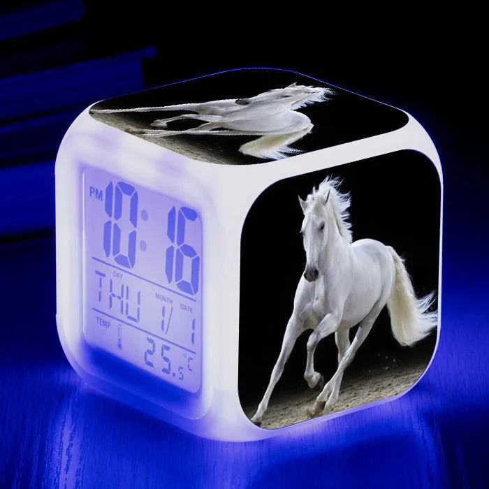 Square creative alarm clock showing LED time display, thermometer reading, and colour-changing design on bedside table