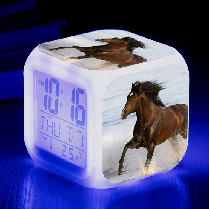 Square creative alarm clock showing LED time display, thermometer reading, and colour-changing design on bedside table