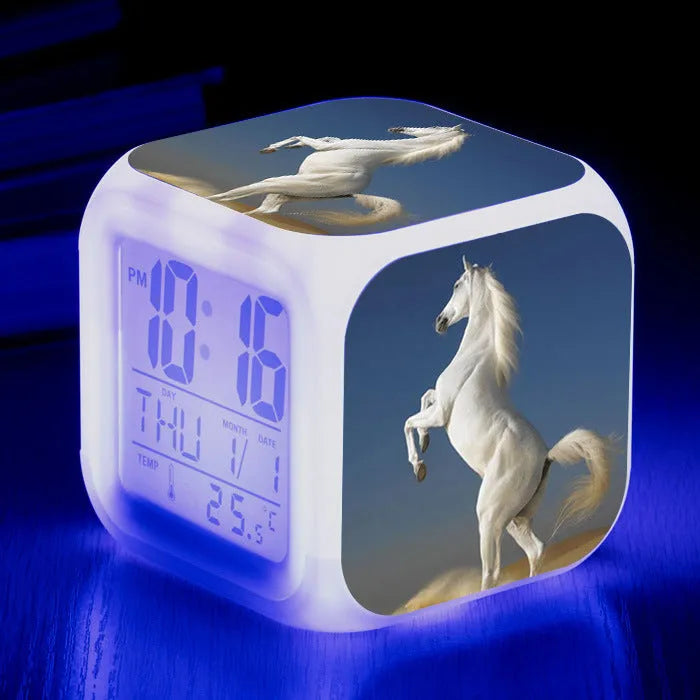 Square creative alarm clock showing LED time display, thermometer reading, and colour-changing design on bedside table