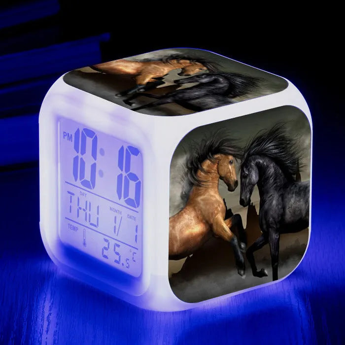 Square creative alarm clock showing LED time display, thermometer reading, and colour-changing design on bedside table