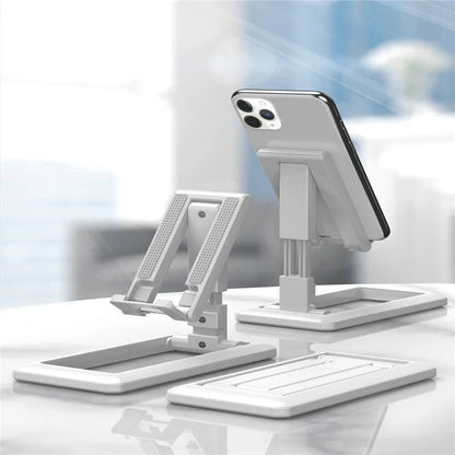 Retractable folding mobile phone stand in an adjusted position on a desktop, shown in one of four colour options.