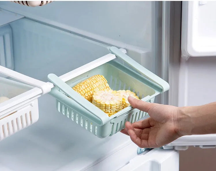 Plastic telescopic refrigerator storage basket in apricot colour, showing multiple compartments for organisation.