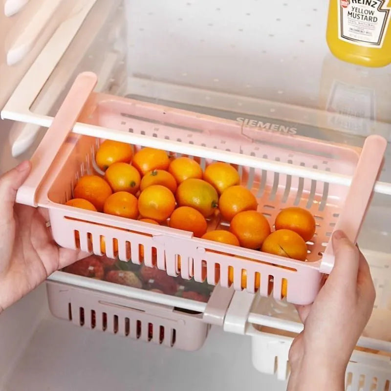 Plastic telescopic refrigerator storage basket in apricot colour, showing multiple compartments for organisation.
