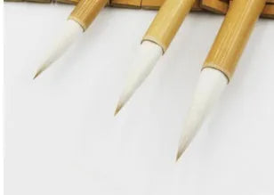 Three traditional Chinese writing brushes with woolen bristles and bamboo handles in large, medium, small sizes