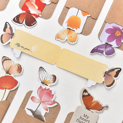 Decorative butterfly-shaped paper bookmark with colourful design, measuring 13.5cm by 5.5cm.