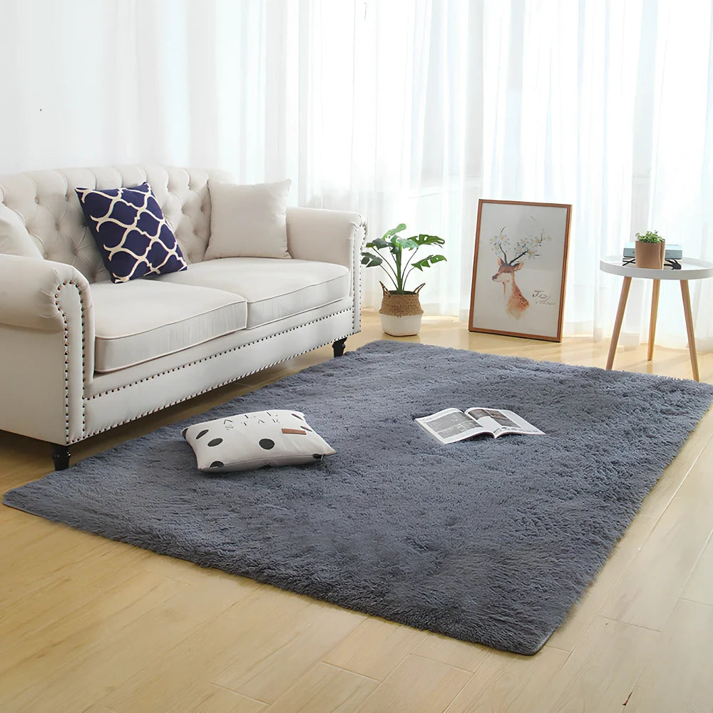 Machine-woven rectangular fluffy rug with 3-5cm deep pile in silver grey colour on wooden floor