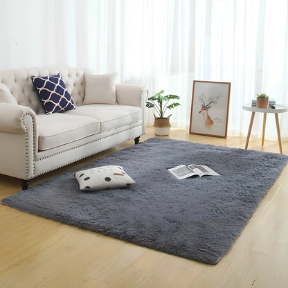 Machine-woven rectangular fluffy rug with 3-5cm deep pile in silver grey colour on wooden floor